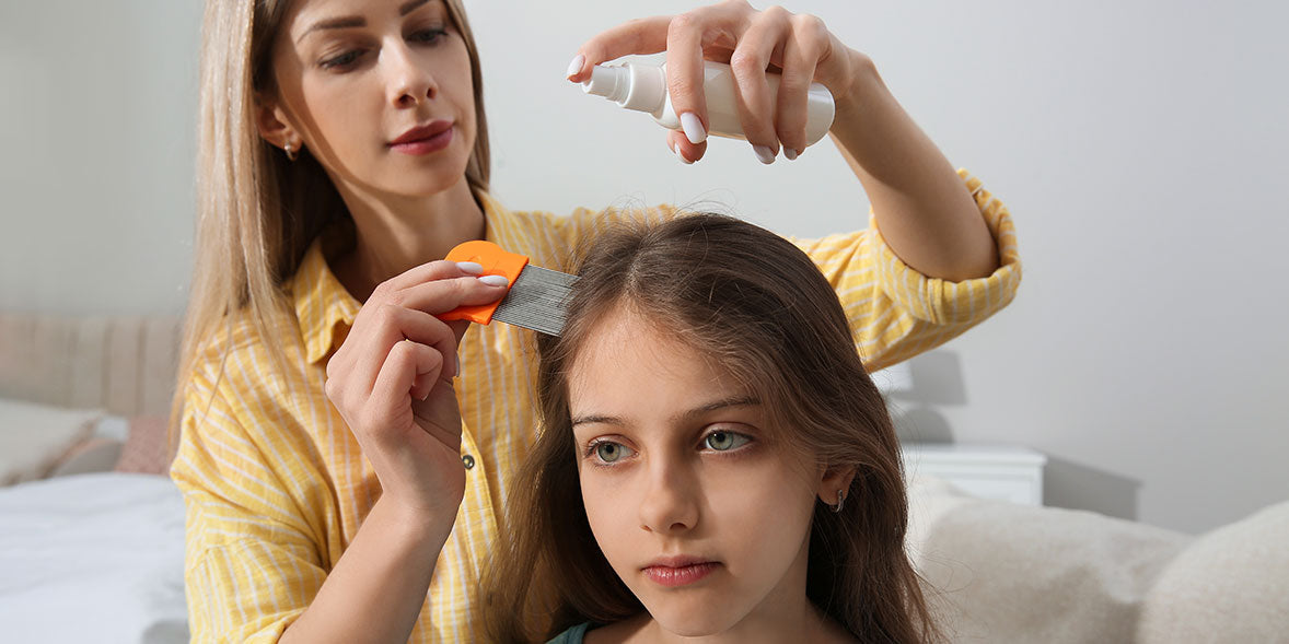 mom applying daughter lice treatment